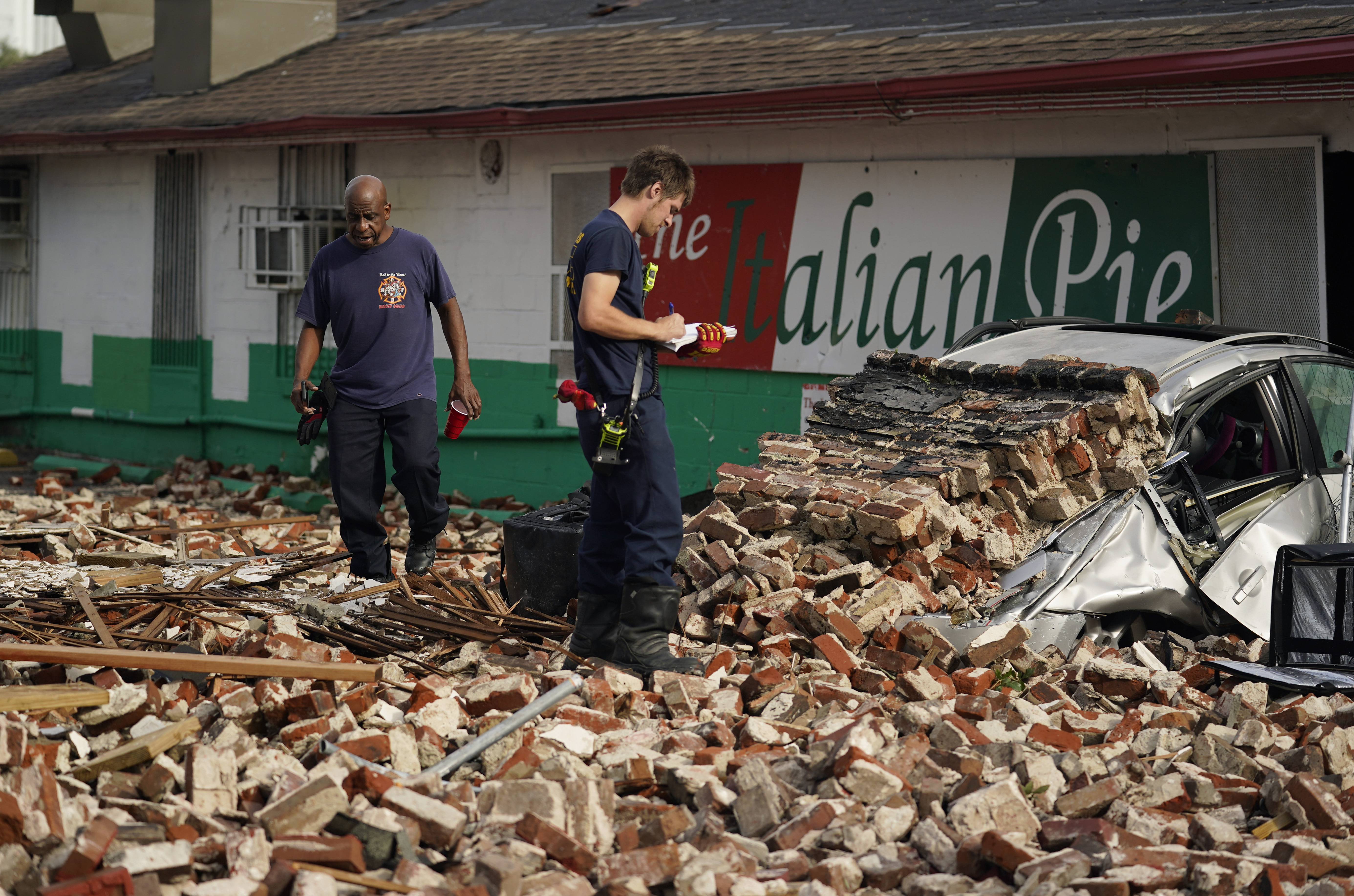 New Orleans firefighters assess damages as they look through debris after a building collapsed from the effects of Hurricane Ida, Monday, Aug. 30, 2021, in New Orleans, La.