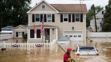 A New Market Volunteer Fire Company rescue crew member wades through high waters following a flash flood, as Tropical Storm Henri makes landfall, in Helmetta, New Jersey, on August 22, 2021. - Tropical Storm Henri slammed into Rhode Island on the US east coast Sunday, knocking out power to thousands of Americans, canceling scores of flights and bringing record rainfall. The storm -- earlier downgraded from a Category 1 Hurricane -- hit land near the town of Westerly at approximately 12:15 PM (1615 GMT), the National Weather Service said.Henri is a rare tropical storm to hit America's northeastern seaboard and comes as the surface layer of oceans warms due to climate change. (Photo by Tom Brenner / AFP) (Photo by TOM BRENNER/AFP via Getty Images)