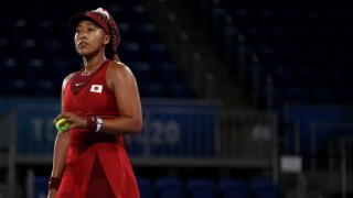 Naomi Osaka holds a tennis ball as she prepares to serve.