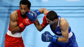 Duke Ragan (red) of Team United States exchanges punches with Albert Batyrgaziev of Team Russian Olympic Committee.