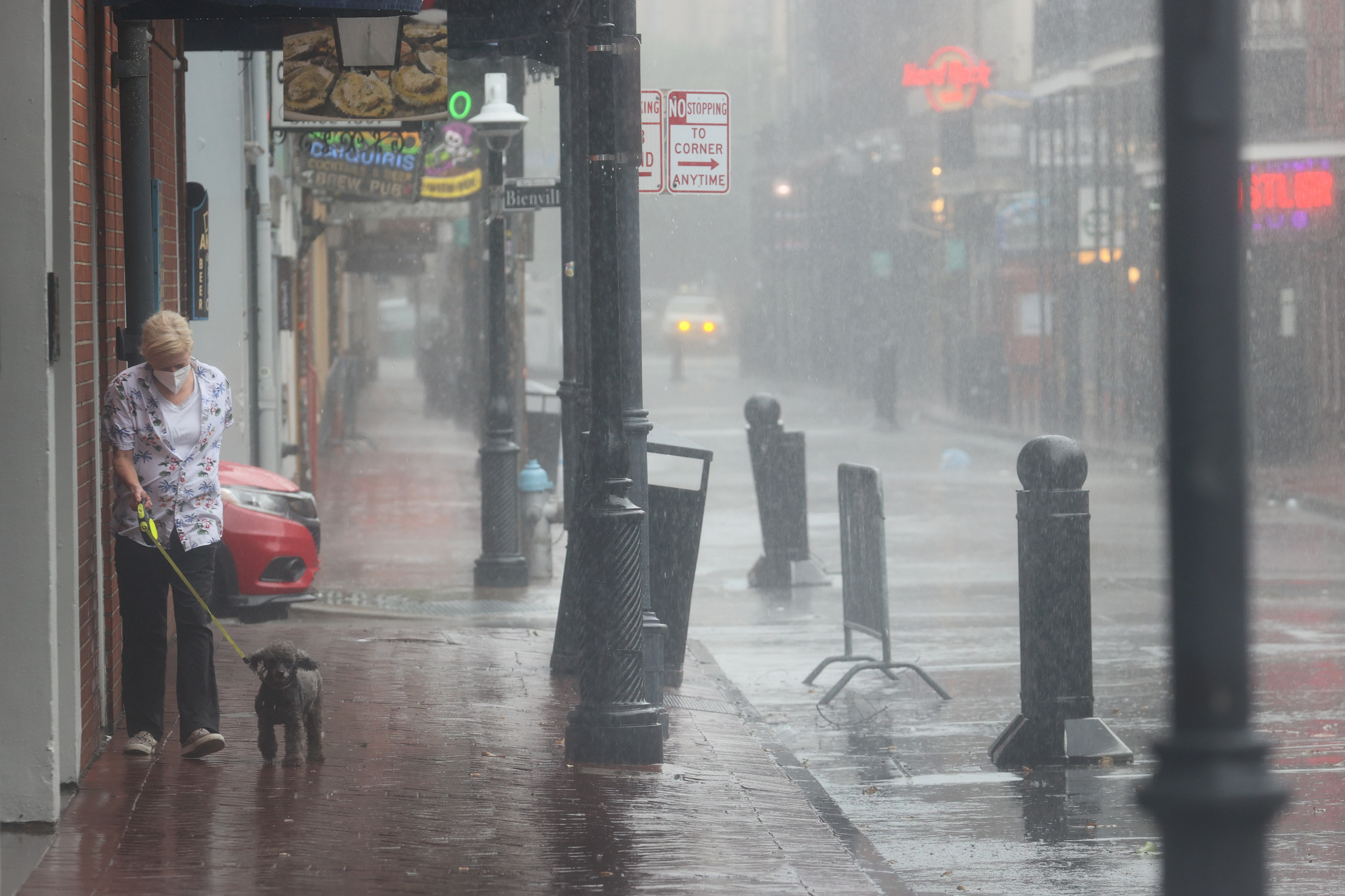 A woman walks her dog in the French Quarter during Hurricane Ida on Aug. 29, 2021, in New Orleans, Louisiana. Ida made landfall earlier Sunday southwest of New Orleans.