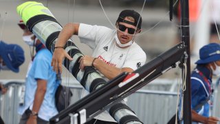Erik Heil of Team Germany packs up his boat after sailing competition is postponed