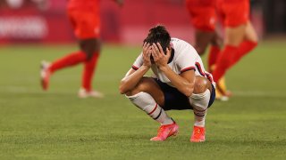 Carli Lloyd, head in hands, after USA lost to Canada in women's soccer at the Olympics