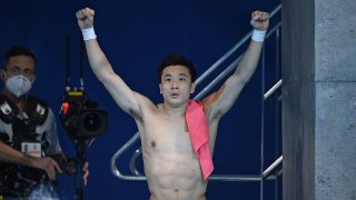 China's Cao Yuan celebrates winning the gold medal in the men's 10m platform diving event at the Tokyo Olympics.