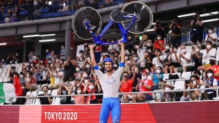 Italian cyclist lifts bike