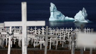 An iceberg is seen at the shore of a graveyard in Nuuk, Greenland, September 13, 2021.