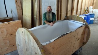 Seth Viddal standing beside human composting vessel