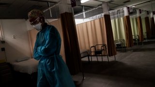 Registered traveling nurse Patricia Carrete, of El Paso, Texas, walks down the hallways during a night shift at a field hospital set up to handle a surge of COVID-19 patients, Wednesday, Feb. 10, 2021, in Cranston, R.I. Rhode Island's infection rate has come down since it was the highest in the world two months ago and many of the field hospital's 335 beds are now empty. On quiet days, the medical staff wishes they could do more.