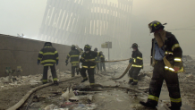 New York City firefighters work amid debris on Cortlandt St. after the terrorist attacks of Tuesday, Sept. 11, 2001.
