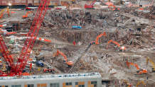 In this Friday Dec. 21, 2001, file photo, recovery and cleanup workers and their machinery continue to clear the site of the Sept. 11 attacks on New York's World Trade Center. In the foreground is a damaged pedestrian bridge. New York City's medical examiner's office is continuing the difficult task of identifying remains recovered from the rubble of the World Trade Center. Just days before the 20th anniversary of the 9/11 terrorist attacks, officials say they have identified the remains of two more people.