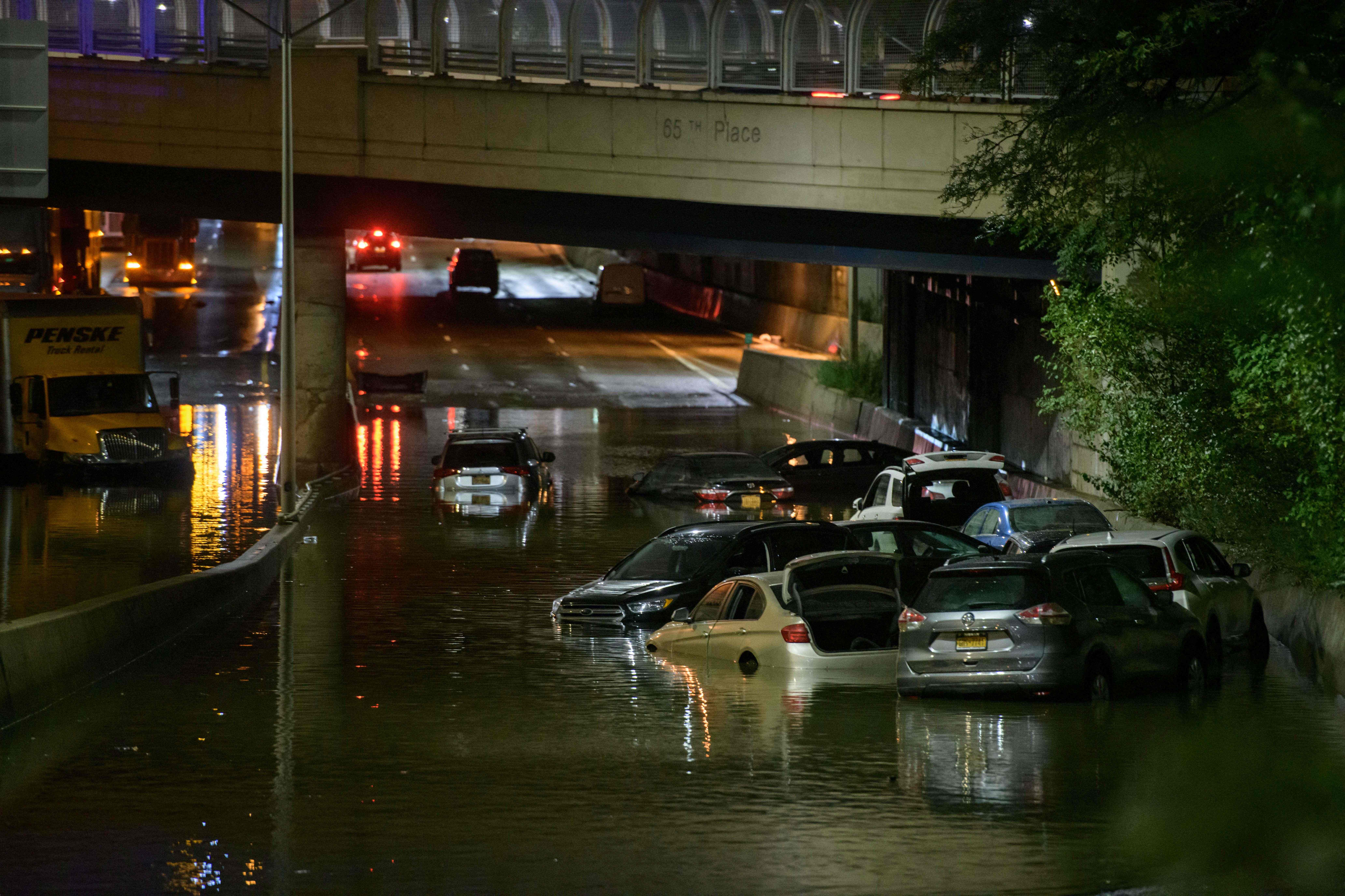 A worker unblocks a drain on a street affected by floodwater in Brooklyn, New York, Sept. 2, 2021, as flash flooding and record-breaking rainfall brought by the remnants of Storm Ida swept through the area.