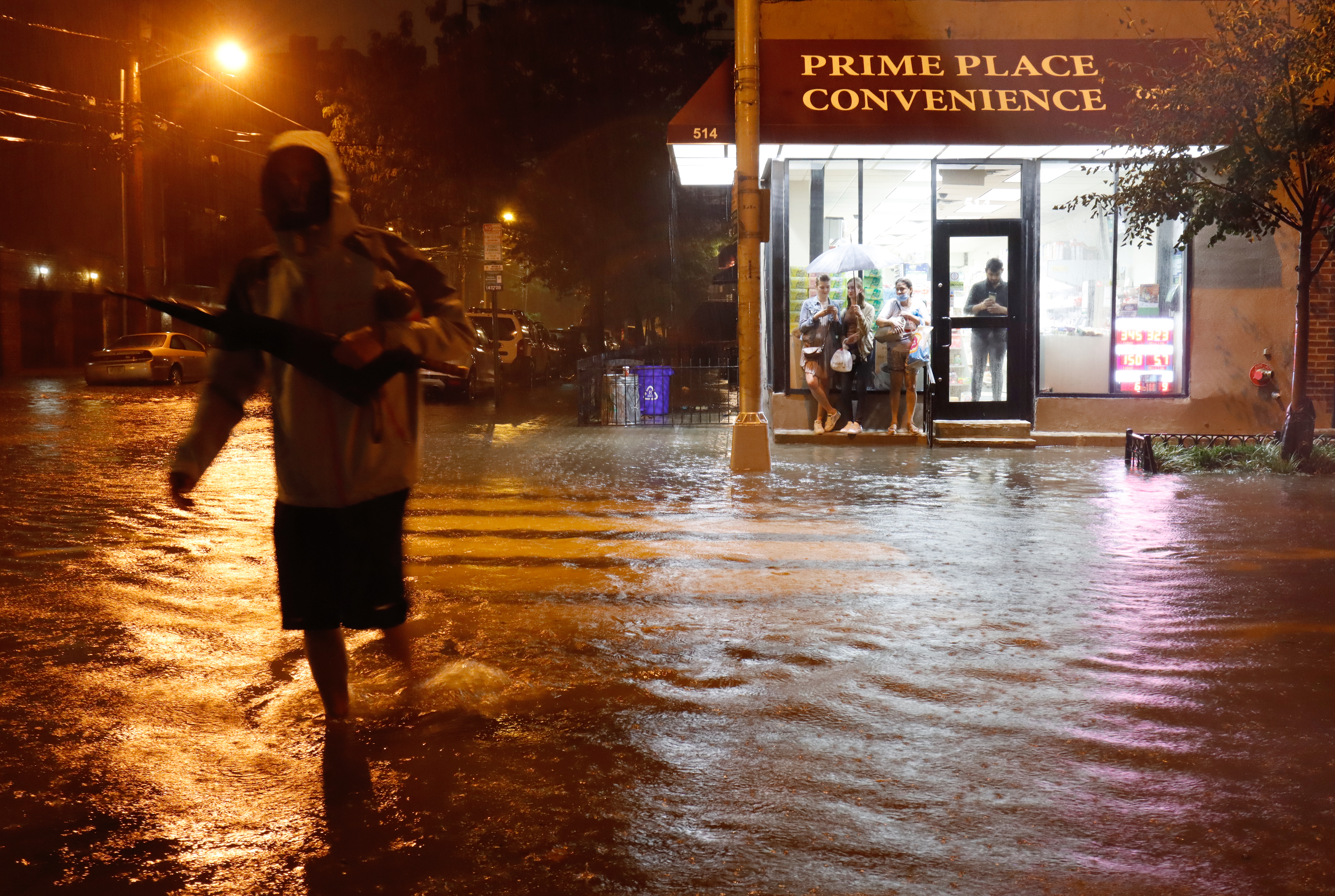 A man is seen crossing a flooded street with with water up to his shin in Hoboken, New Jersea on September 1, 2021. (Photo by Gary Hershorn/Getty Images)