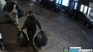 Burglars walking off with stolen goods from store