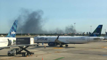 Black smoke filling the sky above Queens seen from JFK Airport.
