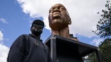 Terrence Floyd stands beside a sculpture of his brother George Floyd