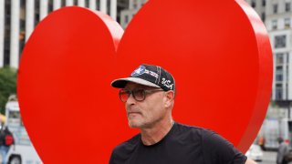 Italian sculptor Sergio Furnari poses for pictures in front of "The Hero Monument" heart sculpture that he made