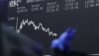 The DAX stock index curve sits on a display screen above a toy model bull at the Frankfurt Stock Exchange, operated by Deutsche Boerse AG, in Frankfurt, Germany.