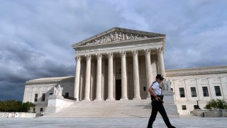 A police officer walks by during a voting rights rally, at the U.S. Supreme Court Thursday, Oct. 28, 2021, in Washington.