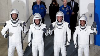 FILE - From front left, European Space Agency astronaut Thomas Pesquet, NASA astronaut Megan McArthur, NASA astronaut Shane Kimbrough and Japan Aerospace Exploration Agency astronaut Akihiko Hoshide leave the Operation and Checkout Building at the Kennedy Space Center in Cape Canaveral, Fla., Friday, April 23, 2021. High wind off the Florida coast has prompted SpaceX to delay the return of four space station astronauts. They were supposed to leave the International Space Station on Sunday, Nov. 7, 2021 with their capsule splashing down in the Gulf of Mexico on Monday morning.