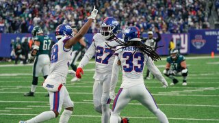 New York Giants' Aaron Robinson (33), right, celebrates with teammates after breaking up a play during the second half of an NFL football game against the Philadelphia Eagles, Sunday, Nov. 28, 2021