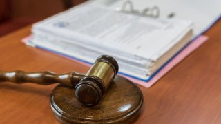 A photo of a gavel and binder full of documents