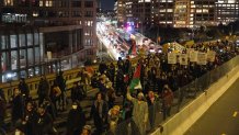 Demonstrators march on the Brooklyn Bridge during a protest against the Kyle Rittenhouse not-guilty verdict near the Barclays Center in New York