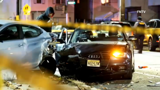 Crime scene tape surrounds two crashed cars after a quadruple shooting.