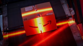 A fast-moving conveyor belt moves a package through a scanning machine on its way to a delivery truck during operations on Cyber Monday at Amazon’s fulfillment center in Robbinsville, New Jersey, U.S., November 29, 2021.