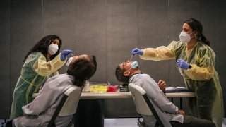 Genview Diagnosis medical assistants Crystal Leyva (L), and Keitia Perez administer Covid-19 sampling tests, to laboratory technicians, at Foxconn Assembly on August 13, 2021 in Houston, Texas.