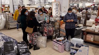 Customers wait in line to checkout during a Black Friday sale at Macy's
