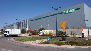 Trucks drive in front of Teva Pharmaceutical Logistic Center