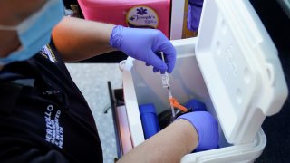 Paramedic Bob Bertollo retrieves a dose of the COVID-19 vaccine for a home-bound patient in Paterson, N.J., Wednesday, May 12, 2021.