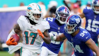 El linebacker Elerson Smith (94), de los Giants de Nueva York, va tras el wide receiver Jaylen Waddle, de los Dolphins de Miami, en duelo de NFL el domingo 5 de diciembre de 2021, en Miami Gardens, Florida.