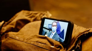 In this photo, a journalist watches their mobile phone showing Derek Chauvin as the verdict in his trial over the death of George Floyd is announced in Minneapolis, Minnesota on April 20, 2021.