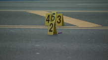 Four evidence markers sit on Eastern Parkway in Brooklyn where police shot and killed a man.
