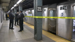 Police in Harlem work the crime scene of a shooting at the 125th Street subway station.