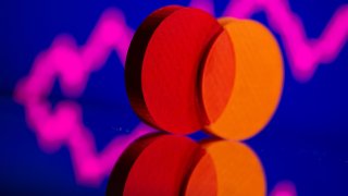 A 3D printed Mastercard logo is seen in front of displayed stock graph in this illustration taken September 20, 2021.