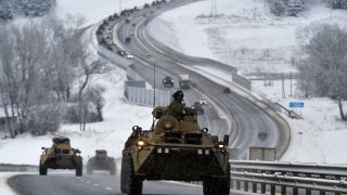 FILE – A convoy of Russian armored vehicles moves along a highway in Crimea, Tuesday, Jan. 18, 2022.