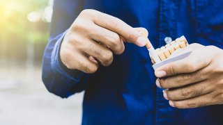 Close up of male hand take a pack of cigarette.