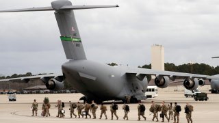 In this photo, U.S. Army soldiers from the 18th Airborne Division walk out to a C-17 aircraft as they deploy to Europe on Thursday, Feb. 3, 2022 from Fort Bragg, N.C.