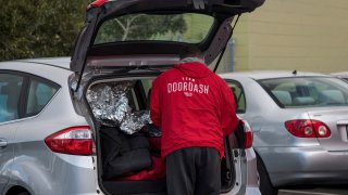 A DoorDash Inc. delivery person arranges an order in the back of a vehicle outside of a DoorDash Kitchens location in Redwood City, California, U.S., on Friday, Nov. 29, 2019.