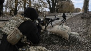 A Ukrainian serviceman aims towards Russian positions outside the city of Brovary, east of Kyiv, on March 9, 2022.