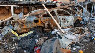 A car destroyed by shelling is seen in a street in Kharkiv, Ukraine, Tuesday, March 22, 2022.