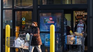 Women shoppers wearing masks leave a Long Island supermarket