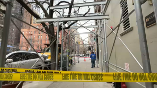 Caution tape blocks sidewalk underneath scaffolding on a corner of the Upper West Side.