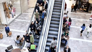 Shoppers ride an escalator at the Westfield Garden State Plaza mall