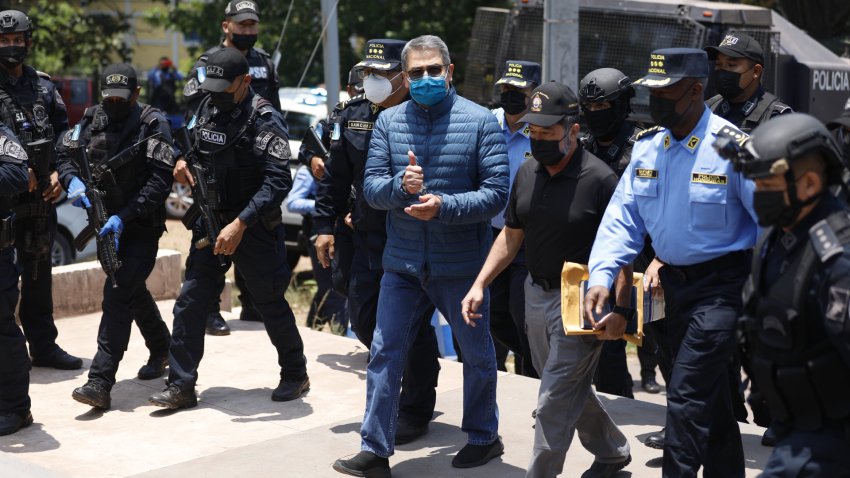 Honduran police officers escort Juan Orlando Hernandez