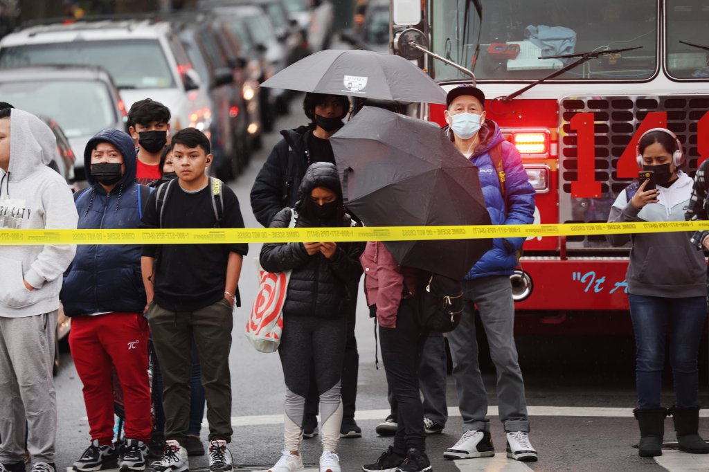 Onlookers gather at the site of a reported shooting outside the 36th Street subway station on April 12, 2022, in the Brooklyn neighborhood of Sunset Park in New York.