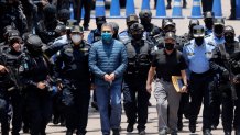 TEGUCIGALPA, HONDURAS - APRIL 21: Former President  of Honduras Juan Orlando Hernandez is escorted  by Members of the Police Special Forces to be extradited to U.S.to face charges of taking bribes from drug traffickers at Honduran National Directorate of Special Forces on April 21, 2022 in Tegucigalpa, Honduras. Hernandez will stand trial for allegedly aiding the smuggling of hundreds of tons of cocaine to America (Photo by Jorge Cabrera/Getty Images)