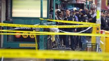 NYPD personnel gather at the entrance to a subway stop in the Brooklyn borough of New York, April 12, 2022.